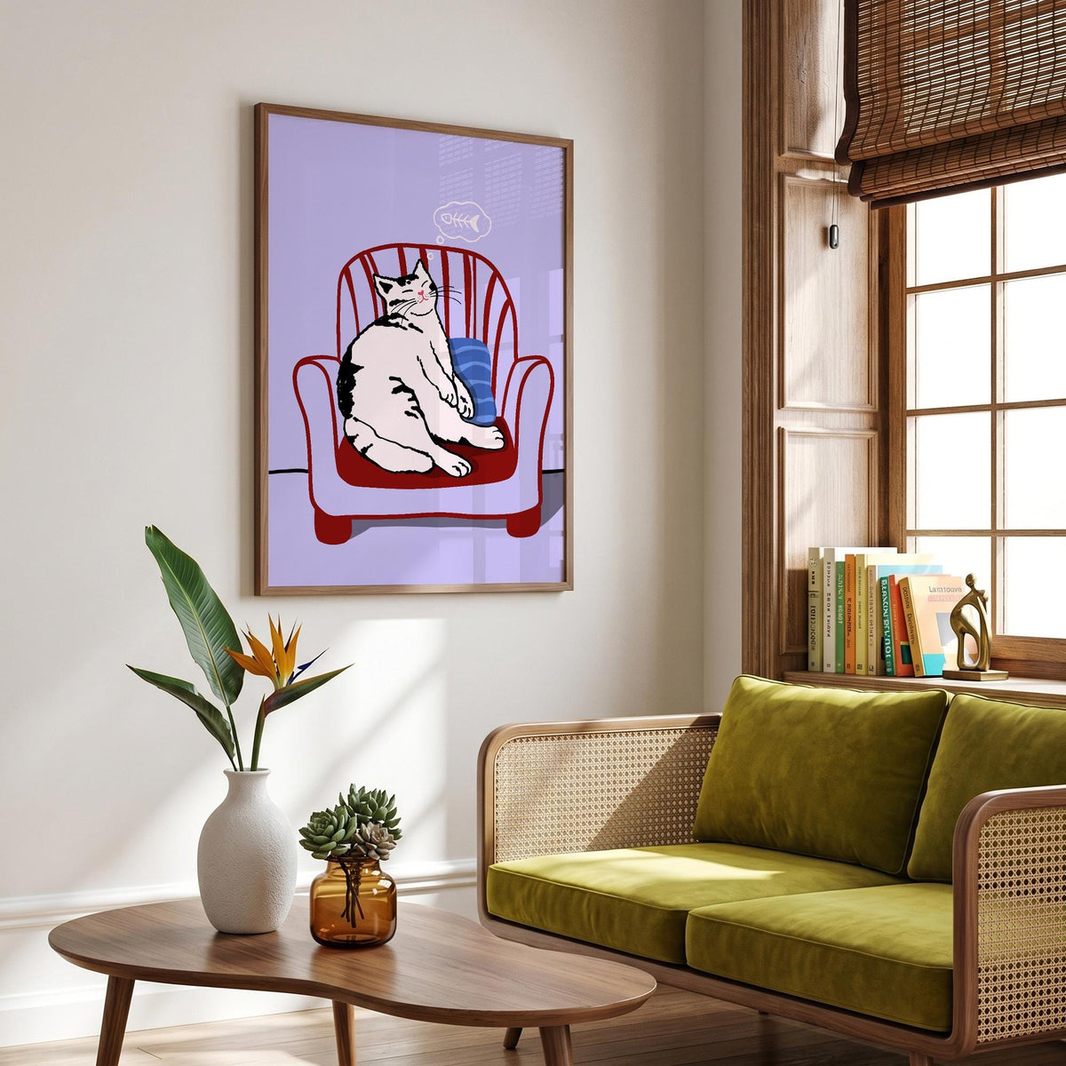 May include: Framed art print featuring a white and black cat lounging in a red chair with a blue pillow. The cat has a thought bubble with a fishbone. The background is a light purple color.