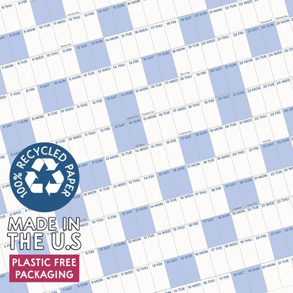 May include: A wall calendar featuring a grid layout with alternating white and light blue columns for days of the month. A circular blue badge states 100% RECYCLED PAPER, MADE IN THE U.S, and PLASTIC FREE PACKAGING in white and black text.