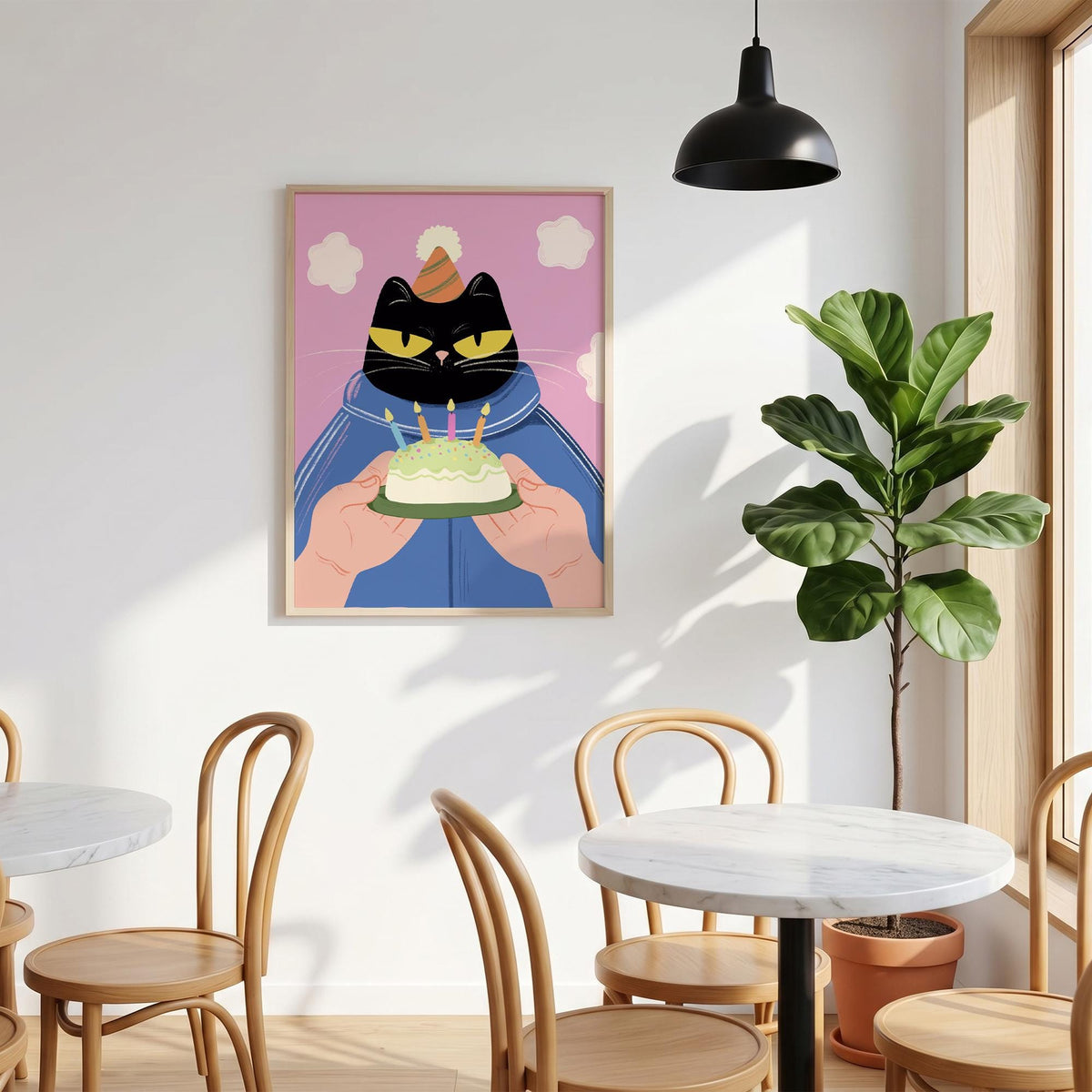 May include: A framed art print featuring a black cat wearing a party hat, holding a birthday cake with lit candles. The cat is set against a pink background with white cloud shapes. The cat's eyes are yellow.