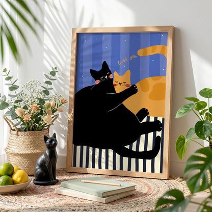 May include: A framed art print featuring a black cat embracing an orange cat. The background has blue stripes and the words "Love you". The print is in a wooden frame and is displayed on a rug.