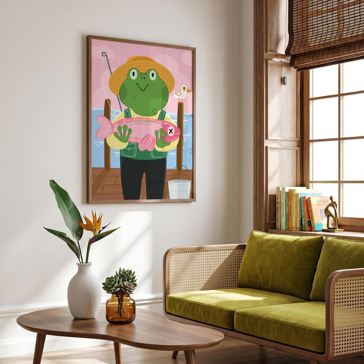 May include: A framed art print featuring a cartoon frog wearing a straw hat and overalls, holding a large pink fish. The background shows a pier, water, and a pink sky. A fishing rod and a small white bucket are also visible.