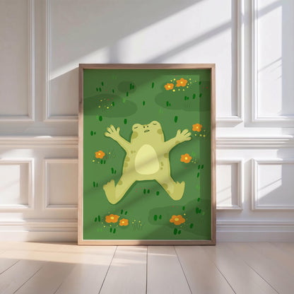 May include: A framed art print featuring a cartoon frog lying on its back in a field of green grass and orange flowers. The frog is light green with a cream-colored belly. The artwork is in a wooden frame.