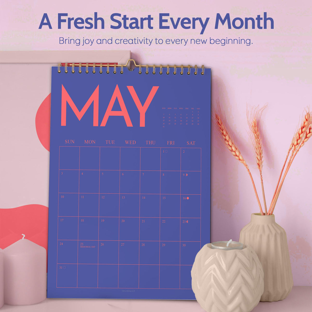 May include: A blue May calendar with a gold spiral binding. The calendar has a grid layout with the days of the week across the top. The text "A Fresh Start Every Month" and "Bring joy and creativity to every new beginning" are at the top.