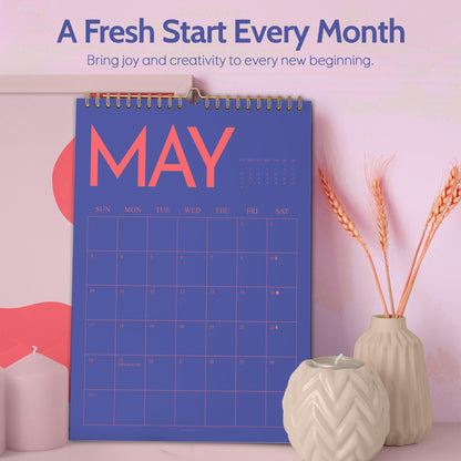 May include: A blue May calendar with a gold spiral binding. The calendar has a grid layout with the days of the week across the top. The text "A Fresh Start Every Month" and "Bring joy and creativity to every new beginning" are at the top.