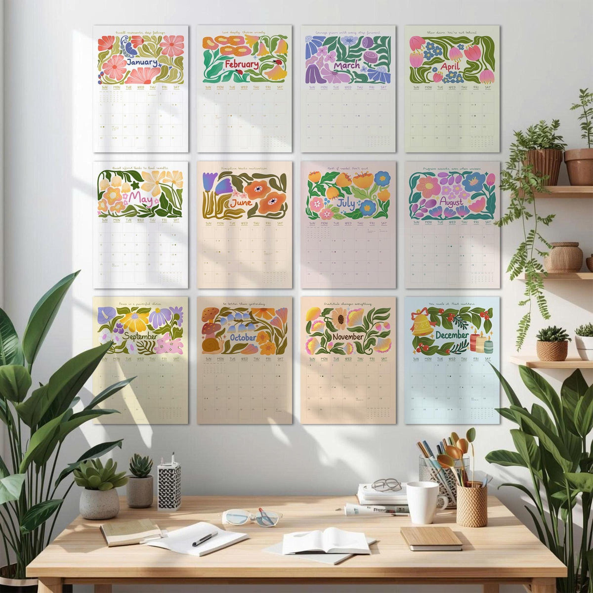 May include: A collection of twelve floral-themed wall calendars, each representing a month of the year. The calendars feature colorful illustrations of flowers and foliage, with the month's name displayed at the top. The calendars are arranged on a white wall above a wooden desk.