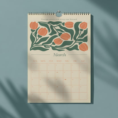 May include: A spiral-bound wall calendar for March, featuring a floral design with orange blooms and green leaves. The calendar has a beige background with a grid of dates and the text "Courage grows with every step forward."