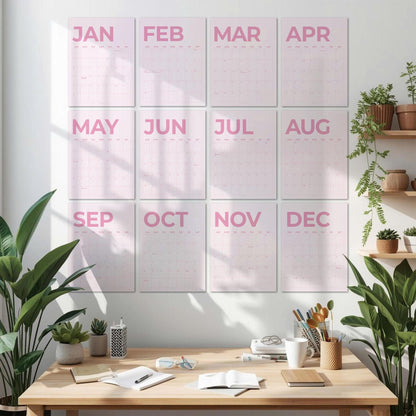 May include: A wall calendar set featuring twelve individual rectangular sheets, each displaying a month from January to December in bold pink lettering. The calendar pages are arranged in a grid of three columns and four rows on a white wall.