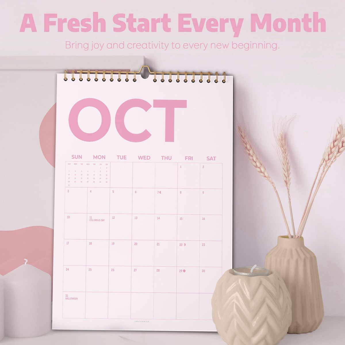 May include: A wall calendar with a white background and pink text displaying the month of October. The calendar features a spiral binding at the top and a grid layout for the days of the week. The text A Fresh Start Every Month is visible.