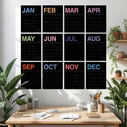 May include: A set of twelve black wall calendars arranged in a grid, each featuring a different month name in a unique pastel color at the top. The calendars display a grid for dates with thin white lines against a black background for each month.