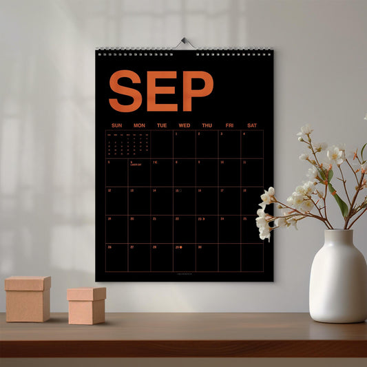May include: A wall calendar for the month of September featuring a black background with bold orange text and grid lines. The calendar displays the abbreviation SEP at the top, followed by a standard monthly grid with days of the week listed above.