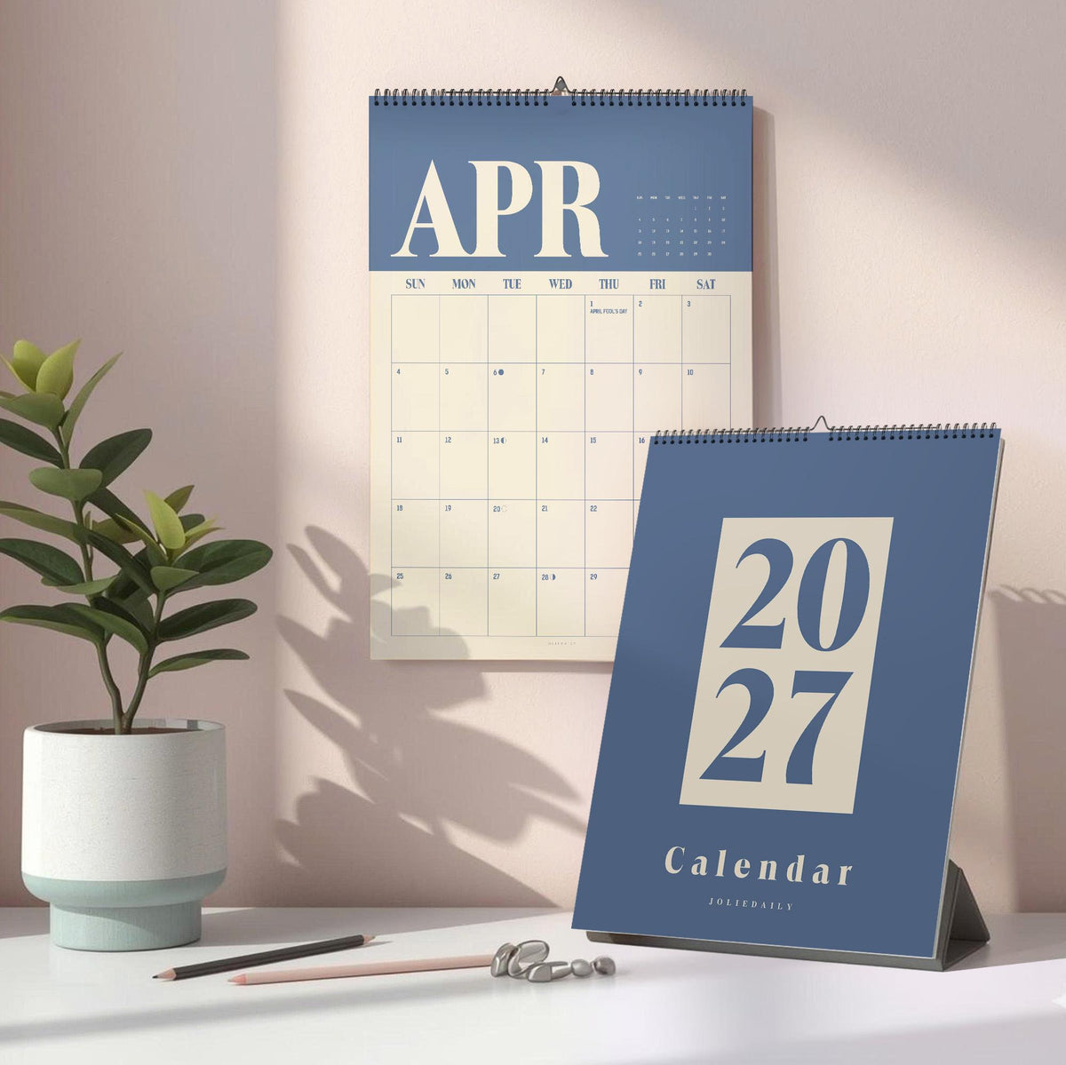 May include: A wall calendar showing the month of April with the text APR and a desk calendar displaying the year 2027 with the text 2027 Calendar. Both calendars feature a blue and cream color scheme with spiral binding at the top.