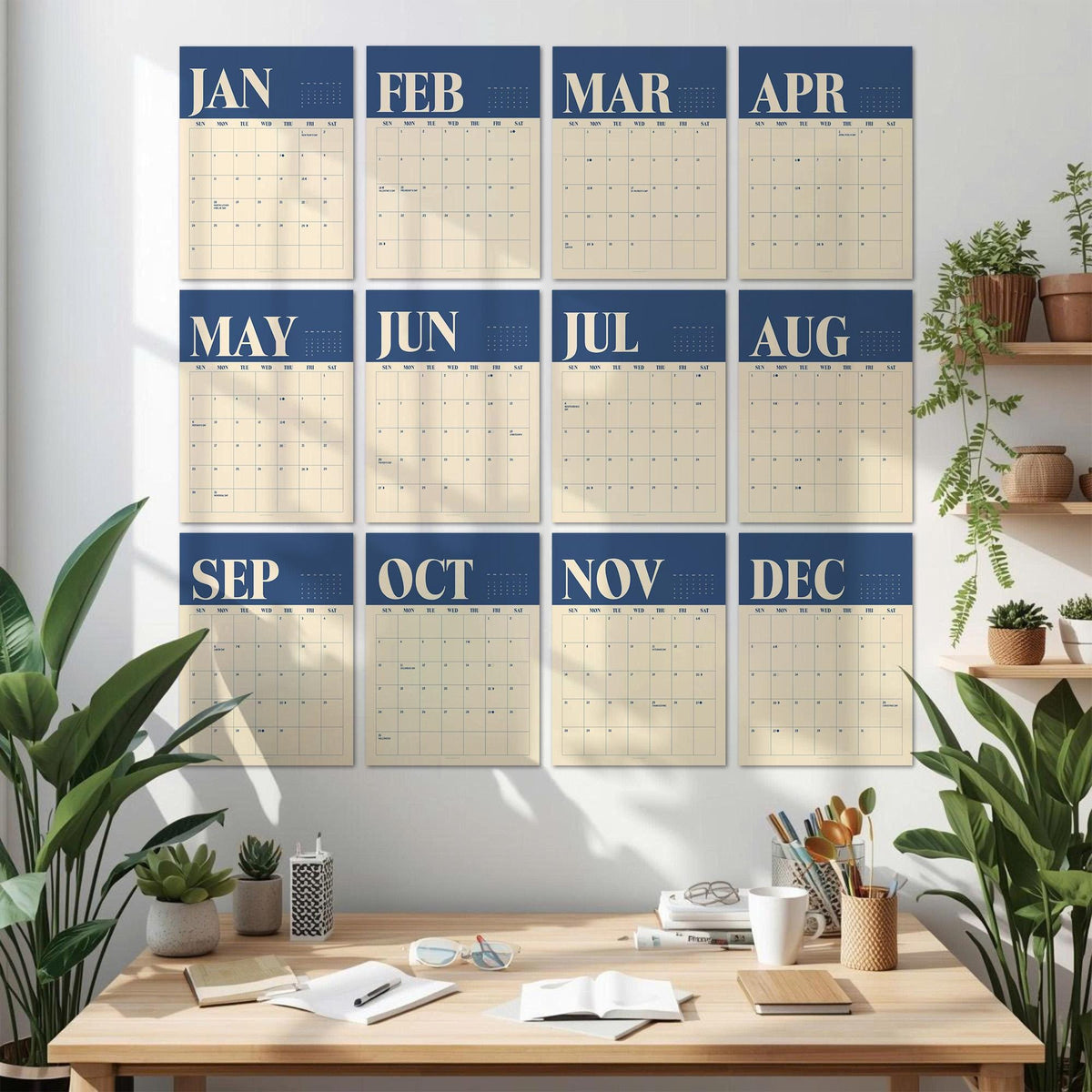 May include: A wall calendar set featuring twelve individual monthly sheets arranged in a grid. Each sheet displays a dark blue header with the month name in white, followed by a cream-colored grid for dates. The months range from January to December.