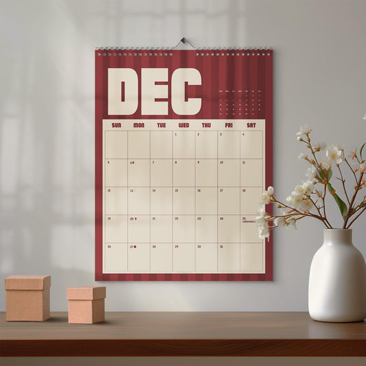 May include: A wall calendar for the month of December featuring a dark red and maroon vertical striped background. The calendar displays the text DEC in large cream letters at the top, with a grid of days and dates in cream and black ink.