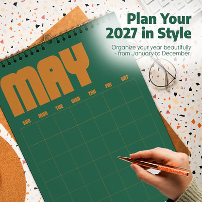 May include: A 2027 wall calendar with a dark green background and large orange text reading MAY. The calendar features a grid layout for days of the week, with text reading Plan Your 2027 in Style and Organize your year beautifully - from January to December.