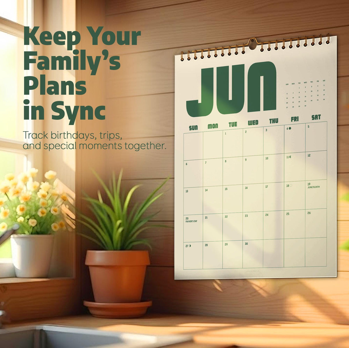 May include: A wall calendar with a cream background and dark green text displaying the month of June. The calendar features a grid layout with days of the week and dates. The text Keep Your Family's Plans in Sync is printed on the left side.