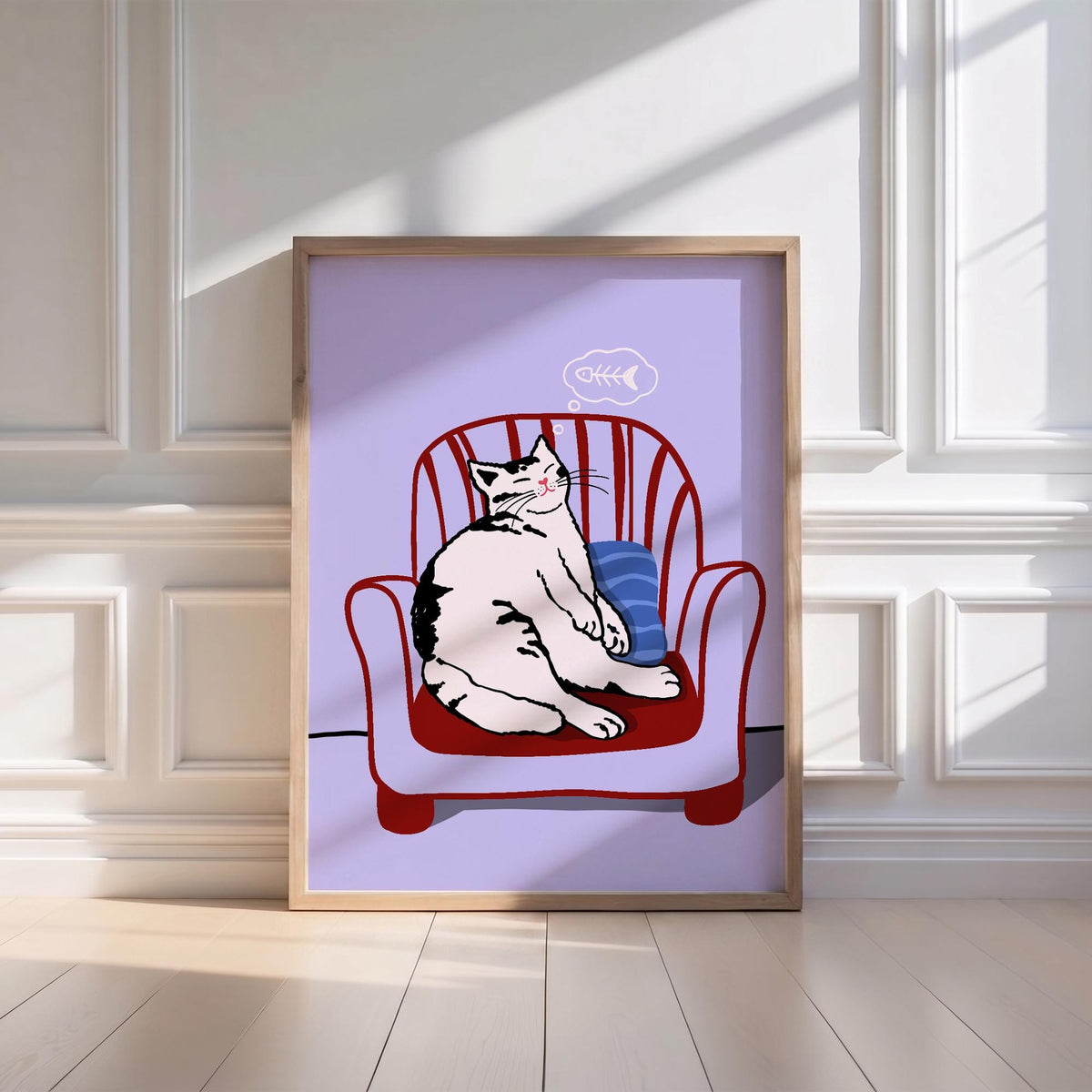 May include: A framed art print featuring a relaxed cat sitting in a red armchair. The cat is white with black markings, and a thought bubble with a fishbone floats above its head. The background is a light purple color.