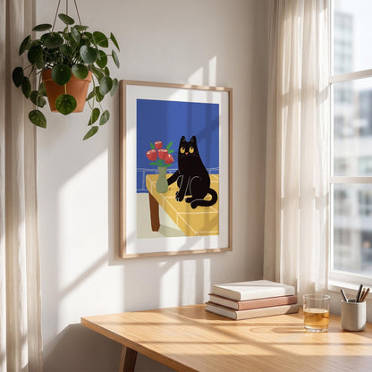 May include: A framed art print featuring a black cat with yellow eyes sitting on a yellow table with a vase of red flowers. The background is blue. The print is in a light wood frame, hanging on a white wall.